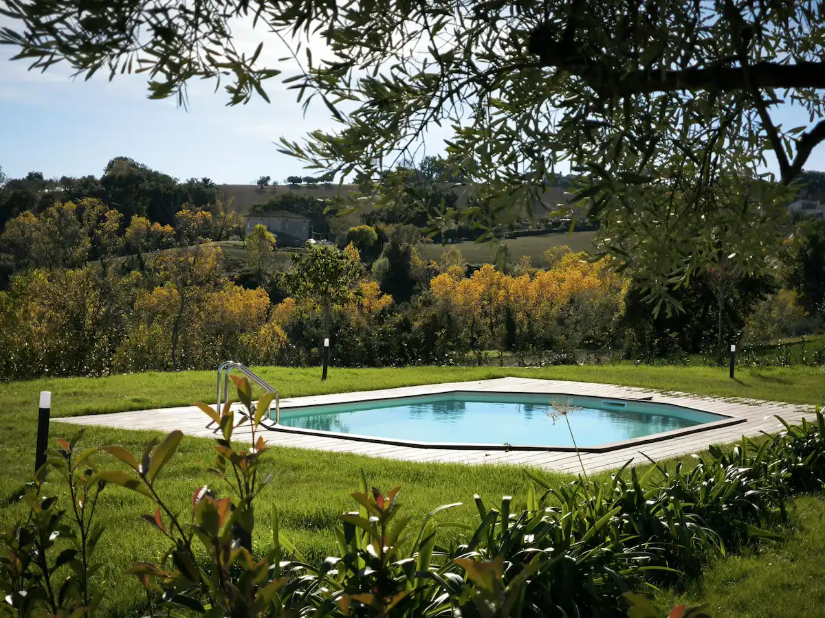 Piscina nel prato con le colline e i boschi autunnali sullo sfondo