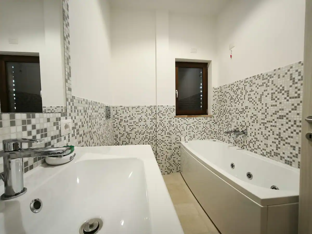 Lavabo e vasca idromassaggio nel bagno con mosaico
